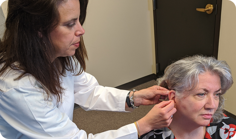 Beltone specialist measuring patients ear for fitment of hearing aids