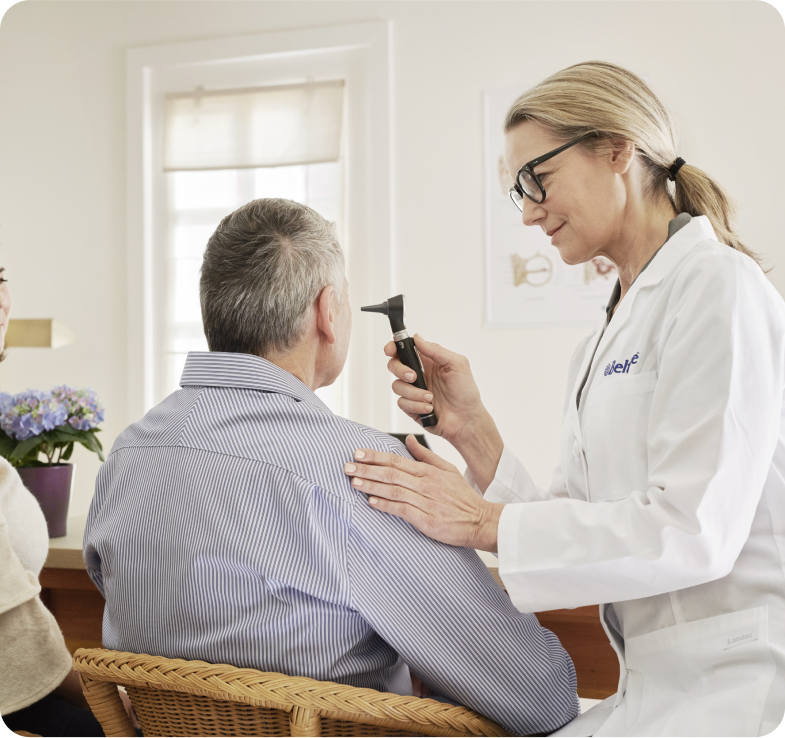 A Beltone technician at the office with a patient during a hearing exam